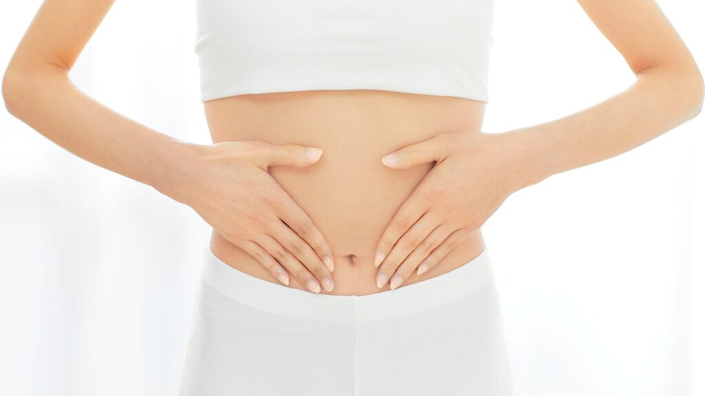 女性が両手でお腹を優しく包んでいる様子