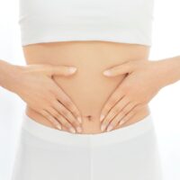 女性が両手でお腹を優しく包んでいる様子