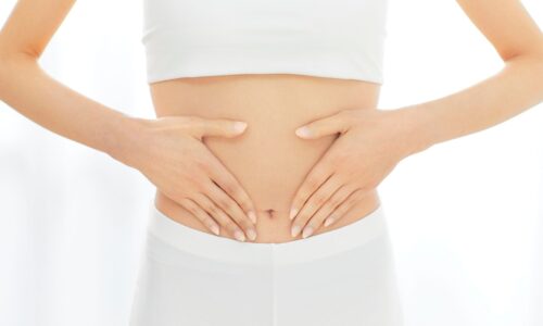 女性が両手でお腹を優しく包んでいる様子