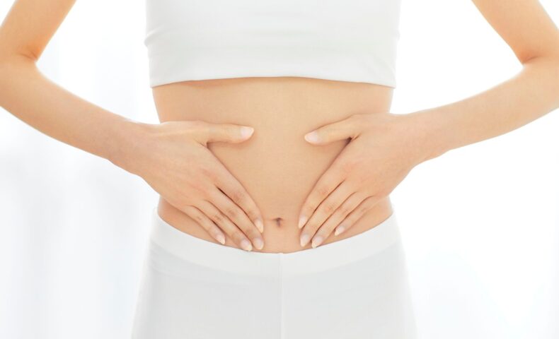 女性が両手でお腹を優しく包んでいる様子